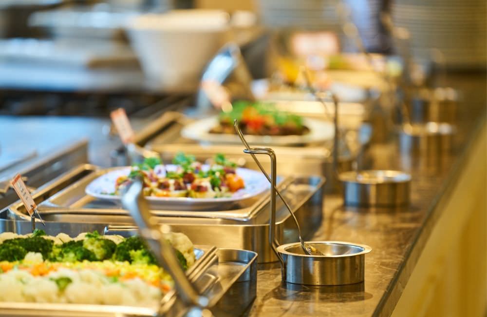 Buffetstation mit frischen Salaten und warmen Speisen